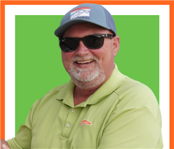 SERVPRO employee, male, posing in front of green background