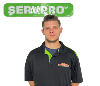 Bradley Casey, SERVPRO employee in uniform in front of green SERVPRO logo